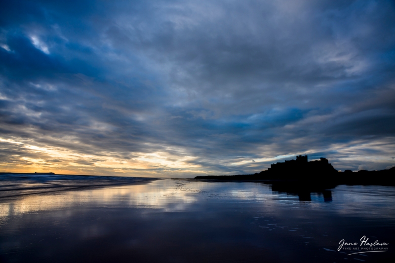 Reflections on a cloudy morning at Bamburgh Castle, Northumberland, UK
